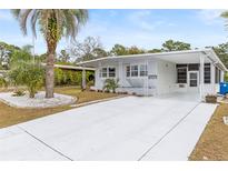 Well-maintained home with an inviting front entrance, pristine landscaping, and a spacious driveway at 14912 Brookridge Blvd, Brooksville, FL 34613