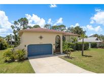Charming single-story home boasts a blue garage door, compass detail, and well-maintained lawn at 4514 Dewey Dr, New Port Richey, FL 34652