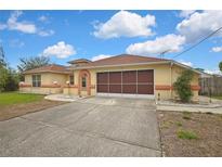 Charming single Gathering home featuring a two-car garage, peach accents and a well maintained front yard at 10412 Ireland St, Spring Hill, FL 34608