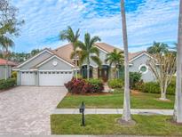 Charming single-story home featuring a three-car garage, lush landscaping, and a tile roof at 12113 Marblehead Dr, Tampa, FL 33626