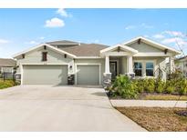 Charming single-Gathering home with a three-car garage, stone accents, and well-maintained landscaping at 6189 Hidden Branch Dr, Apollo Beach, FL 33572