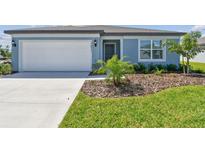 Charming one-story home featuring a manicured lawn and a well-maintained landscape at 12811 Wanderlust Pl, Parrish, FL 34219