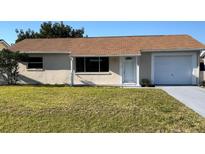 Charming single-story home featuring a well-maintained lawn, a single-car garage and a cozy front porch at 7323 Belvedere Ter, New Port Richey, FL 34655