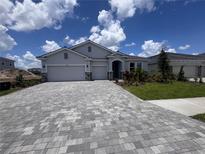 Charming single-story home with a two-car garage, stone accents, a well-manicured lawn, and a paver driveway at 4318 Pullet Ct, Lakewood Ranch, FL 34211