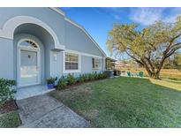 Charming home featuring a beautiful front door, well-maintained lawn, and serene waterfront views at 22 Penzance Ct, Safety Harbor, FL 34695