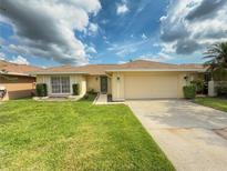 Charming single-story home with a well-manicured lawn and a two-car garage, with lush landscaping at 2267 Heron Cir, Clearwater, FL 33762