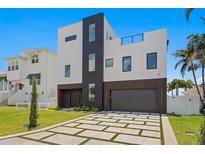 Striking modern home with a two-car garage and a geometrically patterned driveway at 17059 Dolphin Dr, North Redington Beach, FL 33708