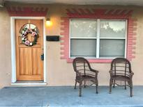 Charming front door adorned with a floral wreath, complemented by two wicker chairs on the cozy porch at 2350 38Th N Ave, St Petersburg, FL 33713