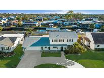 Stunning two-story waterfront home with lush landscaping and a charming front porch, ideal for enjoying serene views at 8716 Hickorywood Ln, Tampa, FL 33615