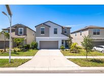 Beautiful two-story home with gray accents, a two-car garage, and landscaped front yard at 16719 Delia St, Wimauma, FL 33598