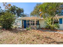 Charming one-story home with blue shutters and inviting front porch, nestled among lush greenery at 8537 Cameo Dr, New Port Richey, FL 34654