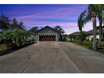 Charming single-story home with a long driveway, lush landscaping, and an attached two car garage at 3369 Houle Ave, Sarasota, FL 34232