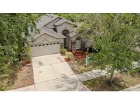 Charming single-Gathering home featuring a two-car garage, stone accents, and well-manicured landscaping at 11321 Flora Springs Dr, Riverview, FL 33579