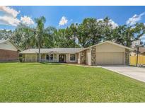 Charming single-story home with a well-maintained lawn, stone accents, and a welcoming front porch at 823 Scenic Heights Dr, Brandon, FL 33511