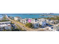 An eye-level aerial view showing a clear shot of the condo buildings and bay at 131 Bluff View Dr # 103, Belleair Bluffs, FL 33770