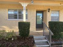 Inviting home entrance featuring a black door with glass inset, surrounded by well-maintained landscaping and concrete steps at 2465 Northside Dr # 1203, Clearwater, FL 33761