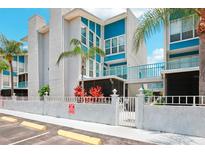 Beautiful condominium complex featuring a white and blue color scheme with lush, tropical landscaping at 343 Rex Pl # F, Madeira Beach, FL 33708