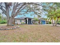 Charming single-story home featuring mature trees, a well-manicured lawn, and a welcoming entrance at 4553 31St E Ct, Bradenton, FL 34203