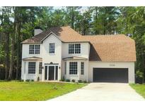 Stunning two-story white brick home featuring a spacious two-car garage and a well-manicured lawn at 19018 Geraci Rd, Lutz, FL 33548