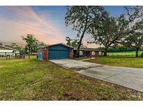 Charming single-story home with brick and siding, a long driveway, and mature trees at 36441 Lake Pasadena Rd, Dade City, FL 33525