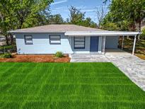 Charming single-story home featuring a carport and a well-maintained lawn at 8902 Temple Park Dr, Tampa, FL 33637