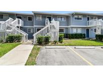 Exterior view of a two-story condo building with white stairs and green landscaping in front at 6033 34Th W St # 45, Bradenton, FL 34210