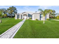 Beautiful single-story home with stone accents, manicured lawn, and a charming walkway leading to the front door at 10920 Flint Estates Dr, Thonotosassa, FL 33592