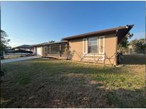 Exterior side view of the home with desert landscaping and an attached garage at 27064 Omni Ln, Punta Gorda, FL 33983