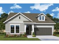 Charming single-Gathering home featuring stone accents, neutral colors, and an attached two-car garage at 5283 Everlong Dr, Apollo Beach, FL 33572