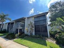 Two-story condo with charming stairs leading to the second floor and a well-manicured lawn at 11201 122Nd Ave # 204, Largo, FL 33778