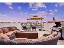 Relaxing rooftop deck with comfortable seating, a fire pit, grill, and stunning city views at 145 Brightwater Dr # 2, Clearwater, FL 33767