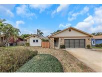 Charming single-story home with stone accents, a two-car garage, mature landscaping, and inviting curb appeal at 435 Meadowlark Ln, Palm Harbor, FL 34683