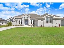 Charming single-story home boasts a well-manicured lawn and appealing architectural details at 5211 Lake Venice Dr, Wimauma, FL 33598