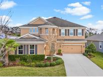 Charming two-story home with landscaped front yard and a two car garage in the daytime at 6307 Brevada Ln, Apollo Beach, FL 33572
