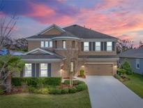 Charming two-story home with landscaped front yard and a two car garage with beautiful sunset at 6307 Brevada Ln, Apollo Beach, FL 33572