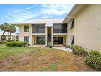 Two-story condo featuring a screened lanai, backyard, and lush landscaping at 7300 Sunshine Skyway S Ln # 108, St Petersburg, FL 33711