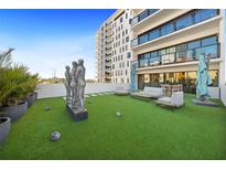Expansive rooftop terrace featuring artificial turf, lounge seating, and modern sculptures with views of the building at 199 Dali Blvd # 407, St Petersburg, FL 33701