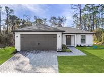 Charming single-story home featuring a paved driveway, two-car garage, and well-manicured lawn at 4621 Kenoska St, North Port, FL 34288