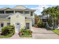 Charming yellow townhome featuring a well-manicured front yard and private driveway at 458 Grant St, Dunedin, FL 34698