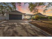 Charming single-story home with a well-manicured lawn, complemented by a spacious driveway and an attached two-car garage at 1695 Honeybear Ln, Dunedin, FL 34698