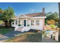 Charming home featuring a brick chimney, a landscaped yard, and a front door at 4056 18Th S Ave, St Petersburg, FL 33711