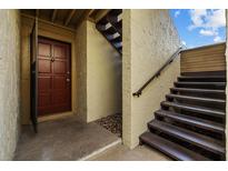 Inviting condo entrance featuring a brown door, convenient stairway access, and secure entryway at 4154 Pinelake Ln # 101, Tampa, FL 33618