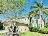 Charming two-story home featuring lush landscaping and a well-maintained lawn at 12127 Luftburrow Ln, Hudson, FL 34669