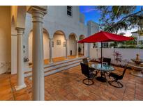 Charming patio area with brick flooring, outdoor seating, and white pillars, perfect for entertaining at 4845 W Sunset Blvd, Tampa, FL 33629
