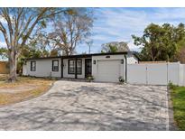 Charming single-story home with well-manicured lawn, gray paved driveway, and attached garage at 4420 Pompano Se Dr, St Petersburg, FL 33705