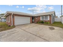 Charming single-story brick home featuring an attached garage and a well-maintained front yard at 6950 113Th St, Seminole, FL 33772
