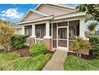 Charming home featuring a welcoming screened front porch and well-manicured landscaping at 302 Latitude Pl, Apollo Beach, FL 33572