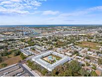 Sprawling aerial view of a condo community featuring a central pool, bocce court, and lush landscaping at 4746 Azalea Dr # 105C, New Port Richey, FL 34652