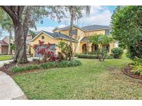 Charming two-story home with a well-manicured lawn and mature landscaping at 5608 Rockfield Loop, Valrico, FL 33596