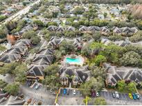 An aerial view of a community featuring a pool, mature landscaping, and ample parking at 2160 Chianti Pl # 11-0117, Palm Harbor, FL 34683